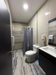a bathroom with a toilet and a sink at Hotel Imperial in Santo Domingo de los Colorados
