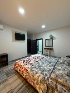 a bedroom with a large bed and a flat screen tv at Hotel Imperial in Santo Domingo de los Colorados