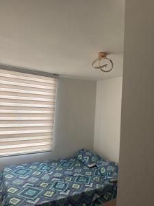 a bedroom with a bed and a window at Apto en el sur de cali in Cali