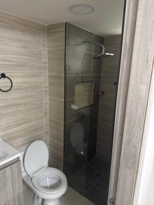 a bathroom with a toilet and a glass shower at Apto en el sur de cali in Cali
