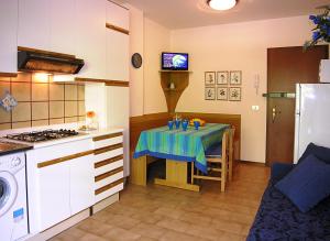 a kitchen with a table with a blue table cloth on it at Appartamenti Nasse in Bibione