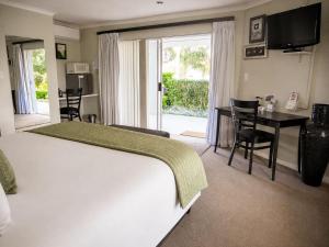 a hotel room with a bed and a desk and a television at Monte Vidéo Guesthouse in Wellington +45 photos