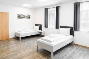 a white room with two beds and a couch at Rote Villa Füssen in Füssen