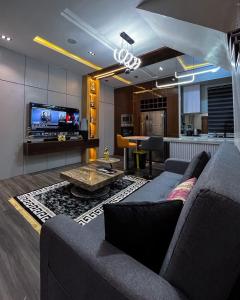 a living room with a couch and a table and a tv at Didi's Apartment in Lekki