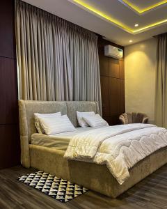a bedroom with a large bed with white sheets at Didi's Apartment in Lekki