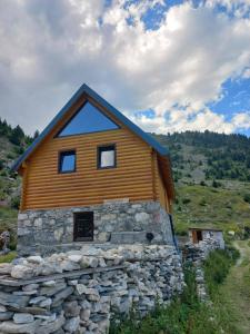 a stone house with a stone wall at Guest House Tofaj in Deçan