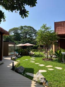 a garden with rocks on the grass and a pathway at Flow Hua Hin - Ice Bath and Villa in Hua Hin