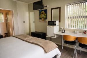 a bedroom with a bed and a table and chairs at Monte Vidéo Guesthouse in Wellington