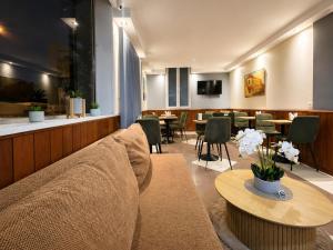 a waiting room with a couch and tables and chairs at Hôtel des Bains 24h 7j Paris centre à 10 min in Maisons-Alfort