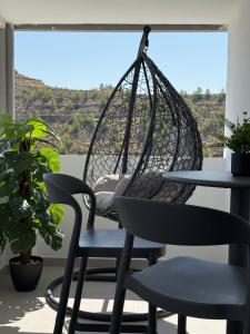a swing chair and a table in front of a window at Panorama Suites in Jorquera
