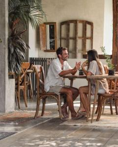 a man and a woman sitting at a table at Boutique Hotel EL NIDO Holbox in Holbox Island