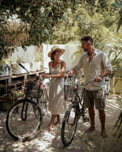 a man and a woman standing next to a bike at Boutique Hotel EL NIDO Holbox in Holbox Island