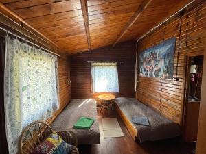 a room with two couches in a wooden cabin at Ośrodek Wypoczynkowy Sielawa in Chrzypsko Wielkie