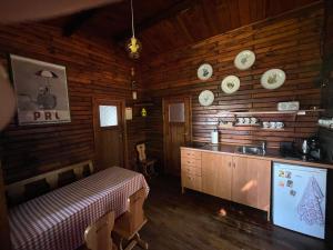 a kitchen in a log cabin with a table and plates on the wall at Ośrodek Wypoczynkowy Sielawa in Chrzypsko Wielkie