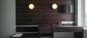 a bathroom with a wooden desk with a tv on the wall at Hotel Golden Heights International in Ernakulam +22 photos