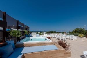 a patio with a swimming pool and tables and chairs at Dolcirive B&B - Porto Cesareo in Porto Cesareo