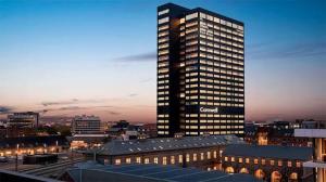 un grattacielo in una città di notte di Comwell Hotels a Arhus
