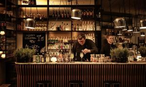 due uomini in piedi dietro un bancone in un pub di Comwell Hotels a Arhus
