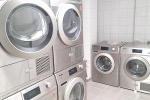 three washing machines and a washer and dryer in a room at Apartment for 5 with a forest view in La Teste-de-Buch +11 photos