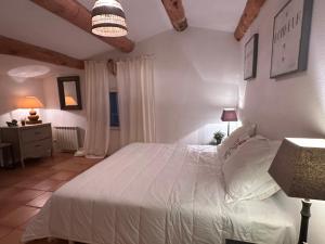 a bedroom with a white bed in a room at Perseïdes in Saignon