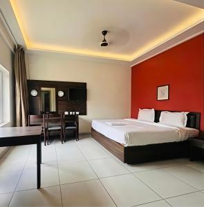 a bedroom with a bed and a desk and a table at Hotel Golden Heights International in Ernakulam
