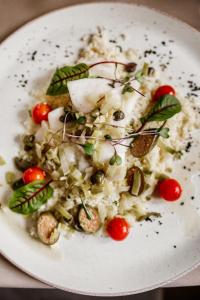 a white plate of food with tomatoes and vegetables at Kasztanowy Pałac in Swadzim