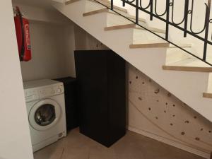 a laundry room with a washer and dryer under a staircase at Aura in Scilla