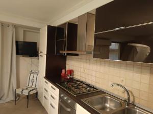 a kitchen with a sink and a stove top oven at Aura in Scilla