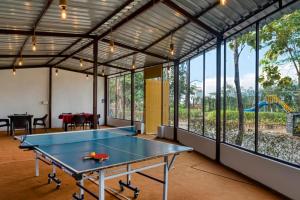 a ping pong table in a room with windows at The Ashoka Tiger in Dhikala Zone