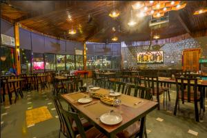 a restaurant with tables and chairs in a room at The Ashoka Tiger in Dhikala Zone