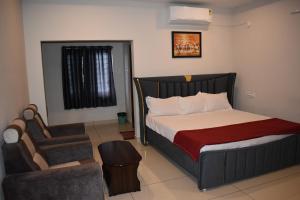 a small bedroom with a bed and a chair at Royal Residency in Vākalapūdi