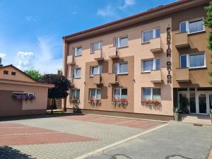a building with windows and flowers in a courtyard at Penzión ORION in Prievidza