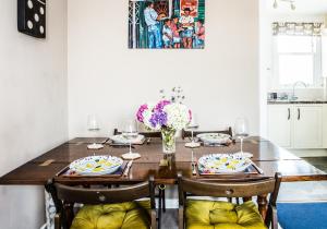 a dining room table with chairs and a vase of flowers at Lynn Cottage in East Linton +26 photos