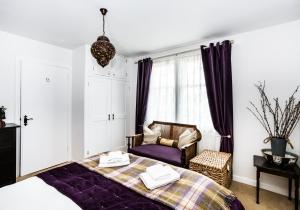a bedroom with a bed and a chair at Lynn Cottage in East Linton