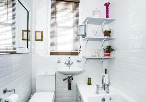 a white bathroom with a sink and a toilet at Lynn Cottage in East Linton