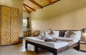 a bedroom with a bed and a large window at The Ashoka Tiger in Dhikala Zone +59 photos