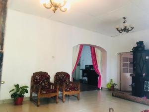 a living room with two chairs and a mirror at Sapphire Homestay in Palle Deltota