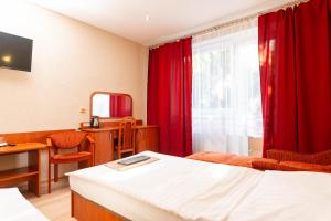 a hotel room with a bed and red curtains at Penzión ORION in Prievidza