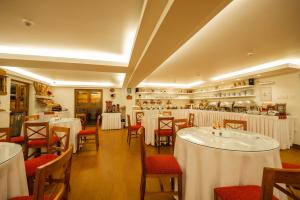 a restaurant with white tables and red chairs at San Agustin Plaza in Cusco +40 photos