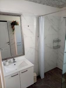 a white bathroom with a sink and a mirror at Apartments Hasanovic Rukavac in Podstražje +39 photos