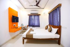 a bedroom with a bed and a desk in a room at Starlighthotels near L&T DLF MIOT Chennai Trade Center Manapakkam in Chennai