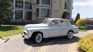 a white car parked in front of a building at Warszawa Hotel in Lviv