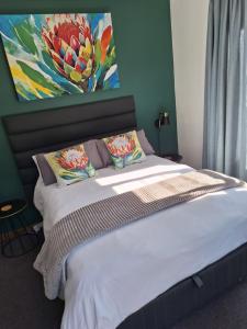 a bedroom with a bed with a painting on the wall at Dee-One's at Napier in Kenridge +14 photos