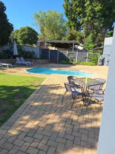 a patio with a table and chairs next to a pool at Dee-One's at Napier in Kenridge