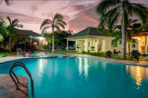 a large swimming pool in front of a house at Paradiso Apartments in Dar es Salaam