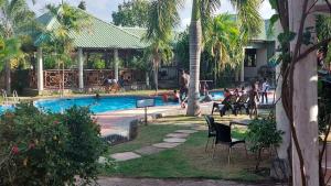 a swimming pool with chairs and people in a resort at Paradiso Apartments in Dar es Salaam