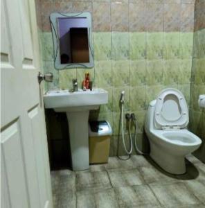 a bathroom with a toilet and a sink at Paradiso Apartments in Dar es Salaam