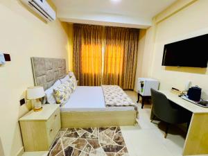 a bedroom with a bed and a desk with a computer at mudha hotel in Hargeysa
