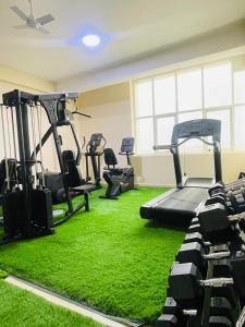 a gym with green carpet and tread machines at mudha hotel in Hargeysa +7 photos