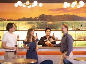 a group of people standing around a bar at Novotel Perth Langley in Perth
